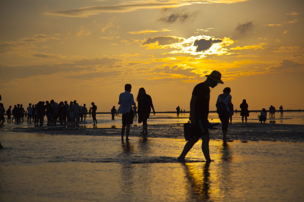 ผู้คนมากมายบนชายหาดที่มีนำ้ขึ้นสูงประมาณ4-5 เซนติเมตรในเวลาตกเย็น